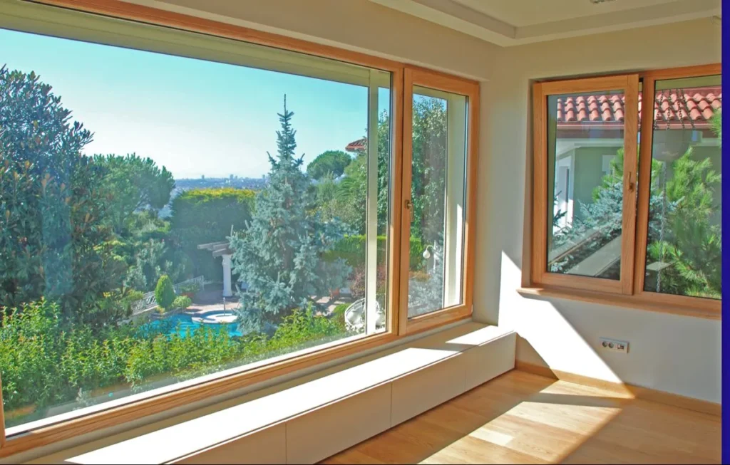 Wood-grain vinyl picture and casement windows overlooking a garden.