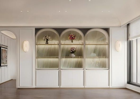 Set of three elegant arched display cabinets with gold frames and illuminated back panels.
